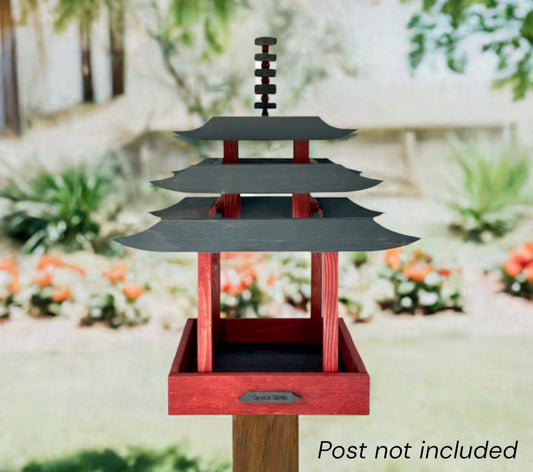 Decorative pagoda bird feeder with a blurred garden background